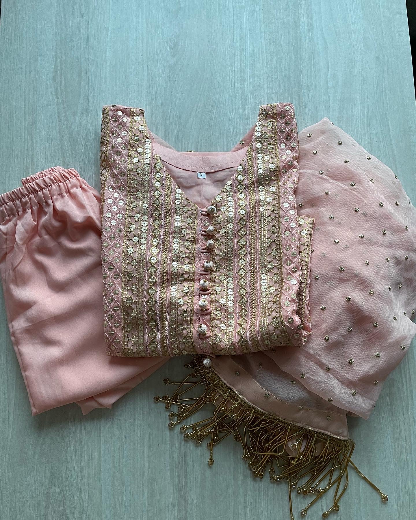 Pink chiffon suit with gold tassels
